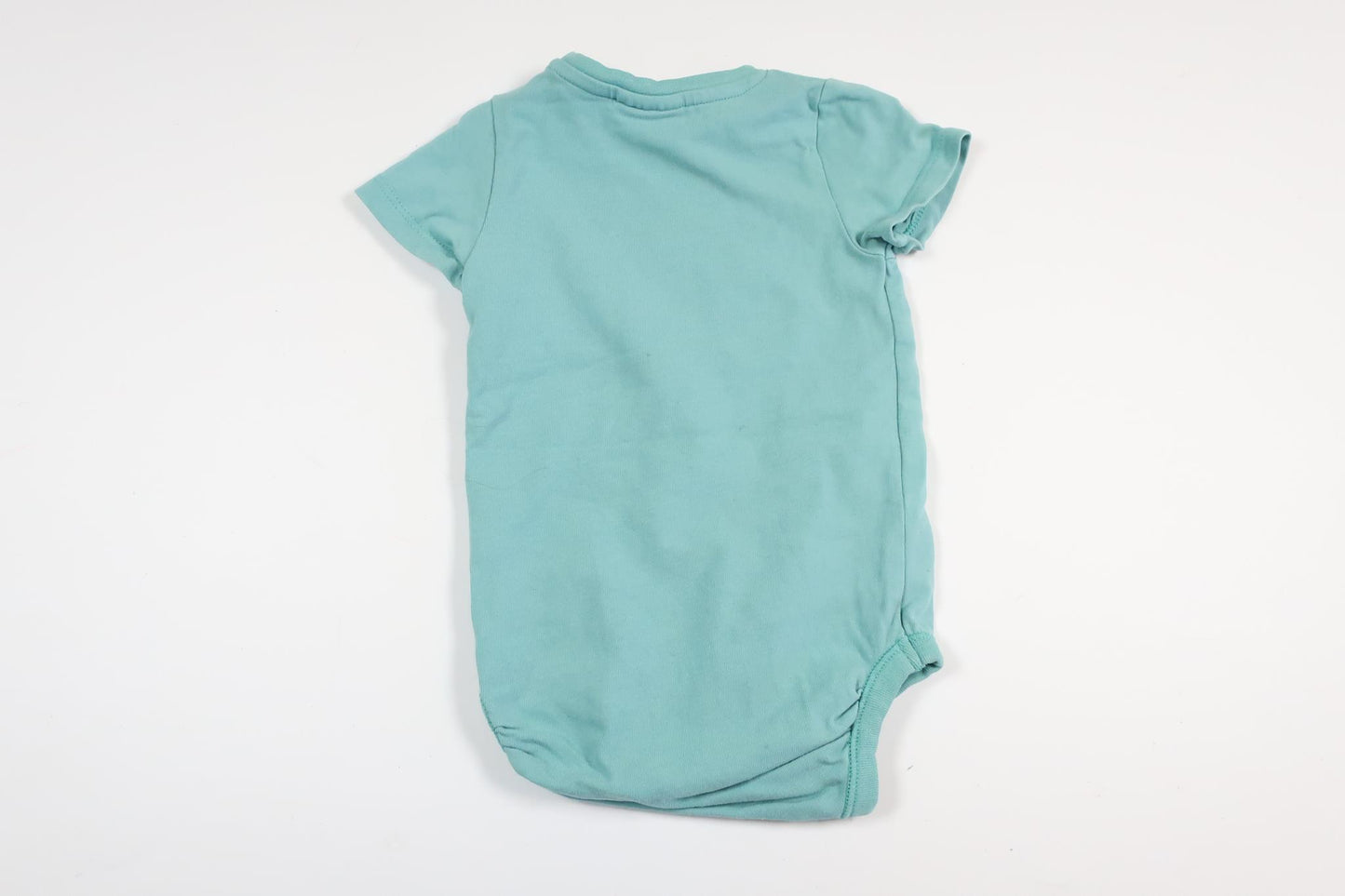 Light blue short-sleeved bodysuit with text from Kappahl in size 62